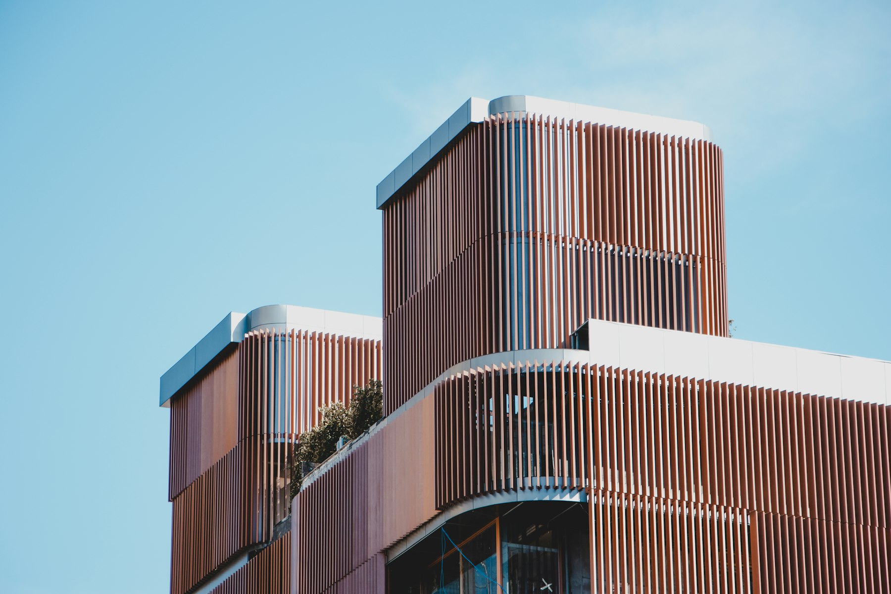Modern mixed-use building with terracotta louvered facade